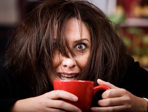 Woman with funny face holding a cup of coffee
