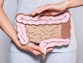 Woman holding drawing of intestines over her gut