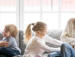 Family Mom Dad Kids Laughing on Couch