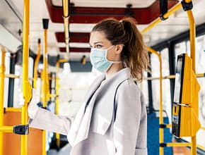 Woman wearing surgical protective mask going to work