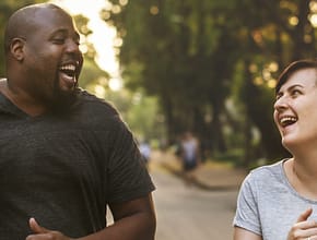 Two people jogging and laughing together having fun.