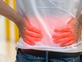 Man's hands on his back with red spot as suffering on backache